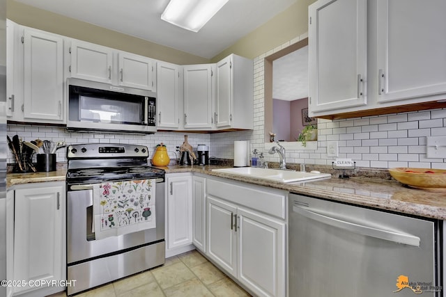 1124 Fred Cir, Anchorage, AK 99515 - kitchen with stainless steel appliances, white cabinets, backsplash, and light stone countertops