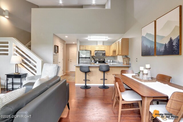 12231 Johns Rd # 2, Anchorage, AK 99515 - dining area featuring wood finished floors, stairway, a high ceiling, and recessed lighting