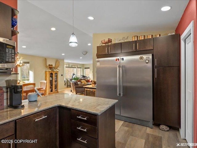 3872 N Charley Dr, Wasilla, AK 99654 - kitchen with stainless steel appliances, dark brown cabinetry, light wood-style floors, a peninsula, and light stone countertops