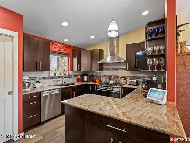 3872 N Charley Dr, Wasilla, AK 99654 - kitchen with stainless steel appliances, wall chimney exhaust hood, tasteful backsplash, dark brown cabinets, and recessed lighting