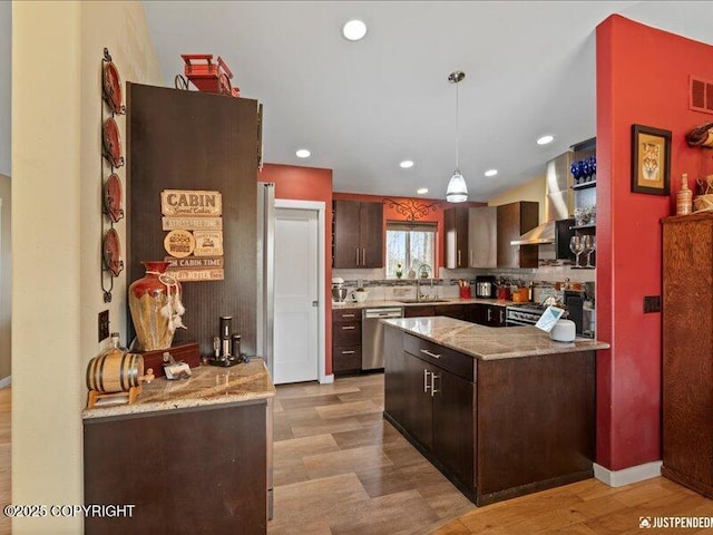 3872 N Charley Dr, Wasilla, AK 99654 - kitchen with stainless steel dishwasher, light wood finished floors, dark brown cabinets, decorative light fixtures, and backsplash