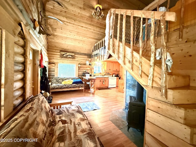 15700 Wild Salmon Way, Ninilchik, AK 99639 - bedroom with rustic walls, a wood stove, wood finished floors, and high vaulted ceiling