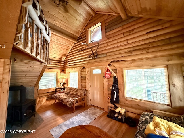 15700 Wild Salmon Way, Ninilchik, AK 99639 - living room with a wood stove, a wood ceiling with exposed beams, wood finished floors, high vaulted ceiling, and log walls