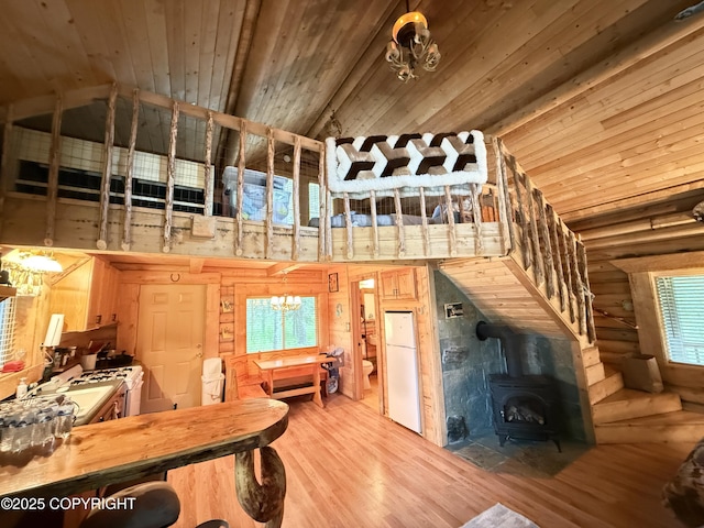 15700 Wild Salmon Way, Ninilchik, AK 99639 - living area with high vaulted ceiling, a wood stove, wood finished floors, and wooden ceiling