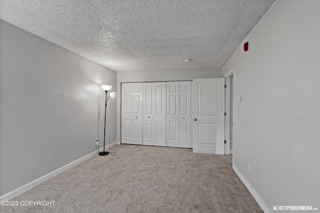 3100 Ward Pl Unit 6, Anchorage, AK 99517 - unfurnished bedroom featuring a textured ceiling, carpet, and a closet
