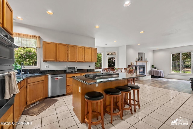 250 Botanical Cir, Anchorage, AK 99515 - kitchen with appliances with stainless steel finishes, a kitchen island, light tile patterned floors, dark countertops, and open floor plan