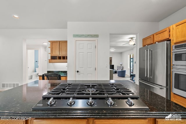250 Botanical Cir, Anchorage, AK 99515 - kitchen featuring appliances with stainless steel finishes, a center island, a ceiling fan, and dark stone countertops