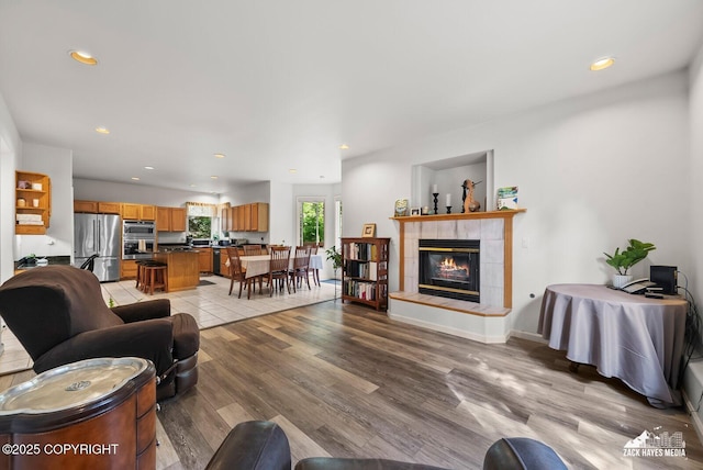 250 Botanical Cir, Anchorage, AK 99515 - living area with recessed lighting, a tiled fireplace, and light wood-type flooring