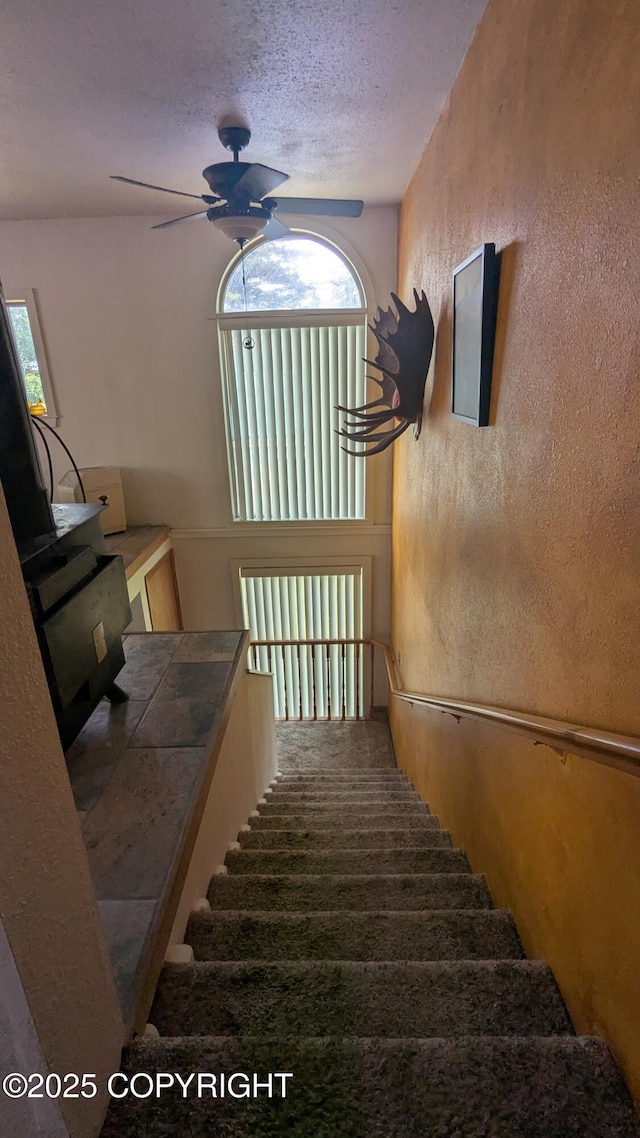 3411 Eagle Ave, Valdez, AK 99686 - stairway with ceiling fan, a textured wall, and a textured ceiling