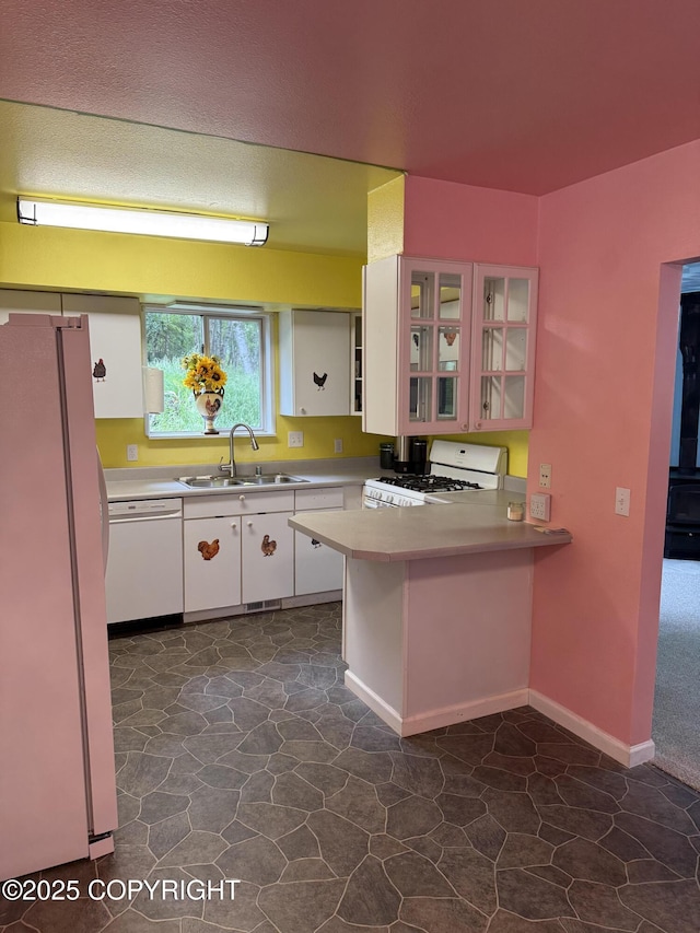 4100 W Peterson Bay Ct, Wasilla, AK 99623 - kitchen with white appliances, a peninsula, white cabinets, and dark stone finish flooring