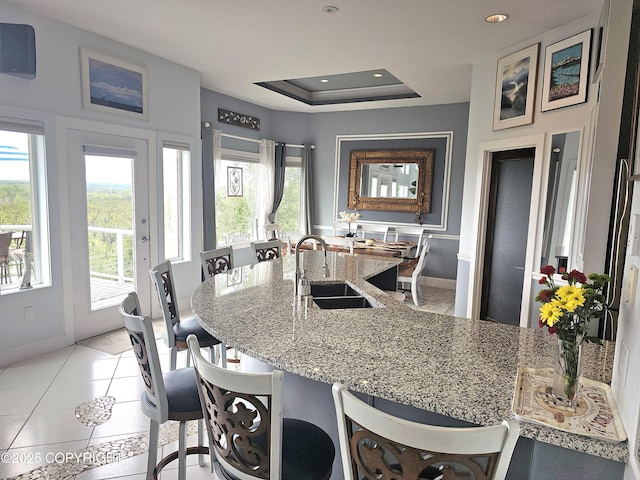 1240 Chinook Dr, Kenai, AK 99611 - kitchen featuring plenty of natural light, light stone counters, a breakfast bar area, recessed lighting, and a tray ceiling