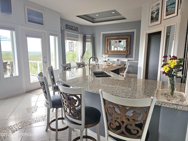 1240 Chinook Dr, Kenai, AK 99611 - kitchen with plenty of natural light, light stone counters, light tile patterned flooring, a breakfast bar area, and recessed lighting