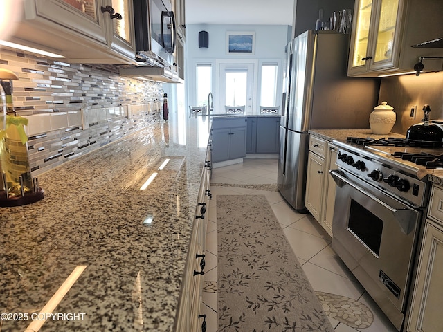 1240 Chinook Dr, Kenai, AK 99611 - kitchen featuring luxury range, backsplash, light stone countertops, glass insert cabinets, and light tile patterned flooring