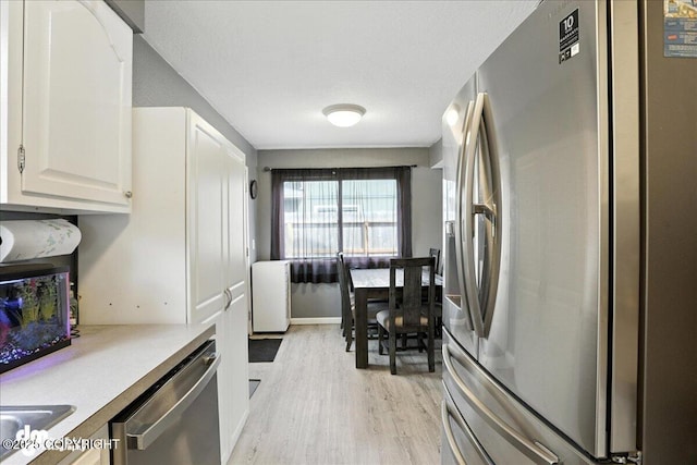 6260 Newt Dr, Anchorage, AK 99507 - kitchen featuring stainless steel appliances, light wood-style floors, white cabinets, and light countertops