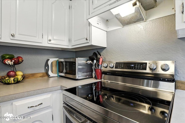 6260 Newt Dr, Anchorage, AK 99507 - kitchen with stainless steel appliances, a textured wall, white cabinets, extractor fan, and light countertops