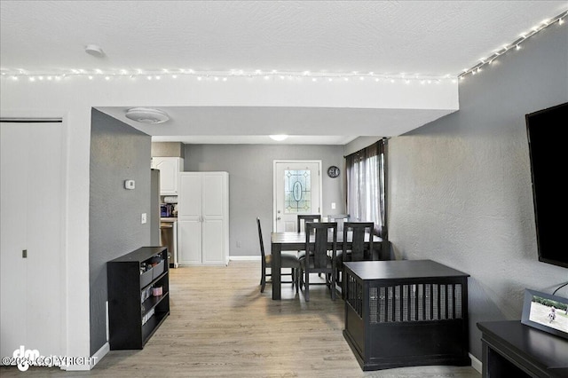 6260 Newt Dr, Anchorage, AK 99507 - dining room with light wood-type flooring, a textured wall, and a textured ceiling