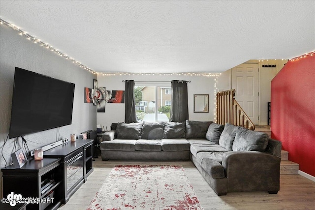 6260 Newt Dr, Anchorage, AK 99507 - living area with light wood-style floors, a textured ceiling, and stairway