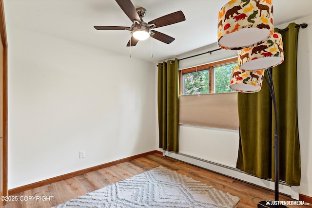 6922 Cutty Sark St, Anchorage, AK 99502 - spare room with baseboard heating, wood finished floors, and a ceiling fan