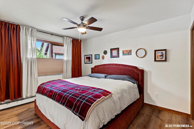 6922 Cutty Sark St, Anchorage, AK 99502 - bedroom featuring a baseboard heating unit, wood finished floors, and a ceiling fan