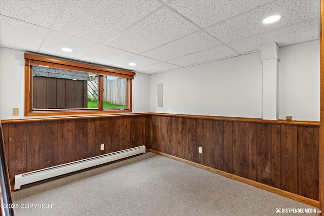 6922 Cutty Sark St, Anchorage, AK 99502 - carpeted spare room featuring a baseboard heating unit, wainscoting, a drop ceiling, wooden walls, and recessed lighting