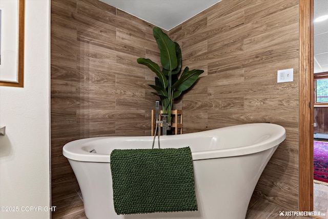 6922 Cutty Sark St, Anchorage, AK 99502 - bathroom featuring a freestanding bath, wooden walls, and a baseboard radiator