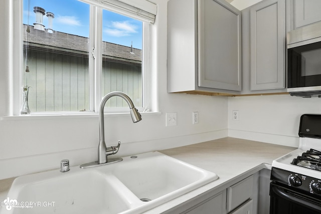 9380 Sea Parrot Cir, Anchorage, AK 99515 - kitchen featuring stainless steel microwave, range with gas cooktop, gray cabinetry, and light countertops