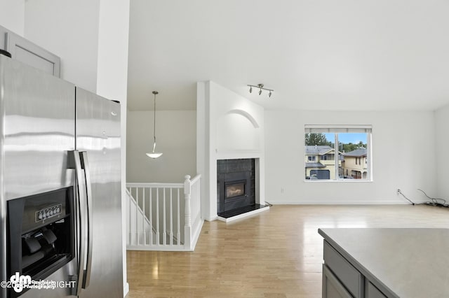 9380 Sea Parrot Cir, Anchorage, AK 99515 - unfurnished living room with light wood-style floors, rail lighting, and a fireplace
