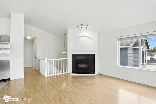 9380 Sea Parrot Cir, Anchorage, AK 99515 - unfurnished living room with wood finished floors, lofted ceiling, and a fireplace