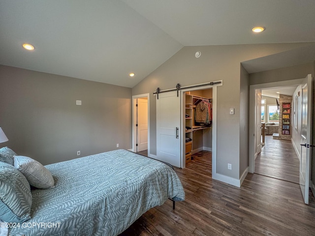 3715 Tajen Ln, Homer, AK 99603 - bedroom featuring a barn door, vaulted ceiling, dark wood-style flooring, a walk in closet, and recessed lighting