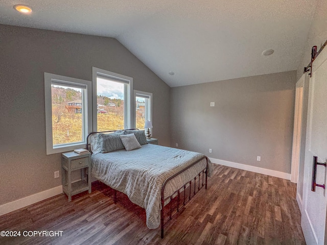 3715 Tajen Ln, Homer, AK 99603 - bedroom with dark wood-type flooring, lofted ceiling, and a barn door