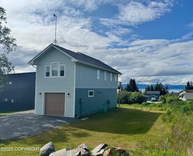 3715 Tajen Ln, Homer, AK 99603 - view of property exterior featuring a yard, a garage, gravel driveway, and board and batten siding