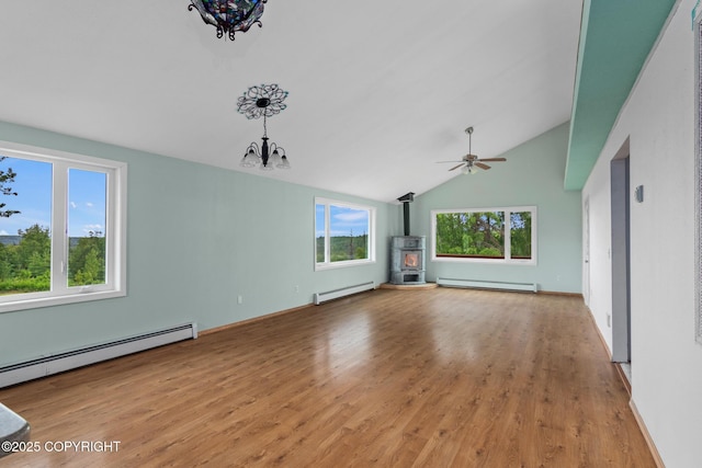 40800 Lopez Ave, Soldotna, AK 99669 - unfurnished living room featuring a baseboard heating unit, a wood stove, a baseboard radiator, healthy amount of natural light, and high vaulted ceiling