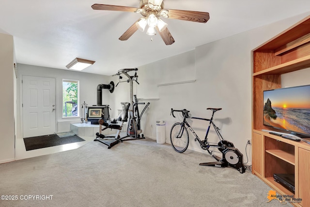 11929 W Wasey Cir, Houston, AK 99623 - workout room featuring a wood stove, light carpet, and a ceiling fan