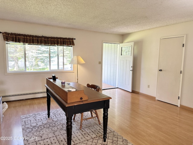 108 S Leibrock St, Soldotna, AK 99669 - home office featuring baseboard heating, light wood-type flooring, and a textured ceiling