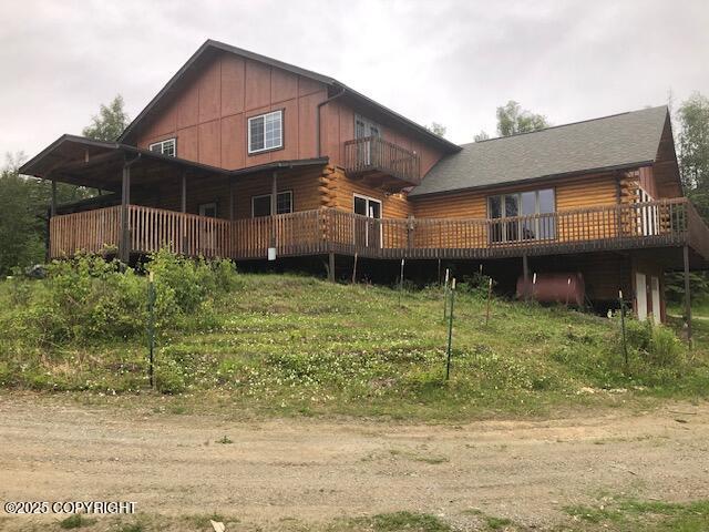 4033 W Sunrise Rd, Wasilla, AK 99623 - back of property featuring log exterior, a wooden deck, a balcony, and board and batten siding