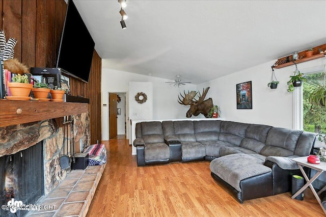 10845 Anvik Cir, Eagle River, AK 99577 - living room with light wood-style floors, vaulted ceiling, a ceiling fan, and a stone fireplace