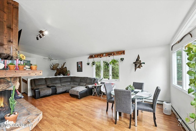 10845 Anvik Cir, Eagle River, AK 99577 - dining room with baseboard heating, light wood finished floors, lofted ceiling, a fireplace, and a ceiling fan