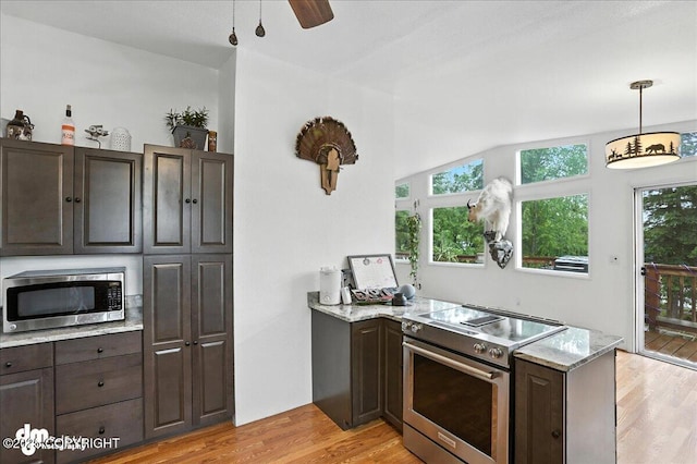 10845 Anvik Cir, Eagle River, AK 99577 - kitchen featuring stainless steel appliances, a peninsula, light wood finished floors, dark brown cabinetry, and light stone countertops