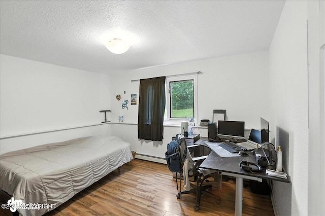 10845 Anvik Cir, Eagle River, AK 99577 - bedroom featuring wood finished floors, baseboard heating, an office area, and a textured ceiling