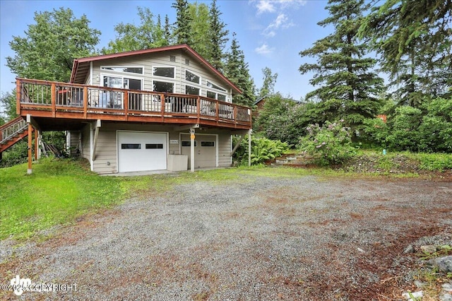 10845 Anvik Cir, Eagle River, AK 99577 - view of front facade with a wooden deck, dirt driveway, stairs, and an attached garage