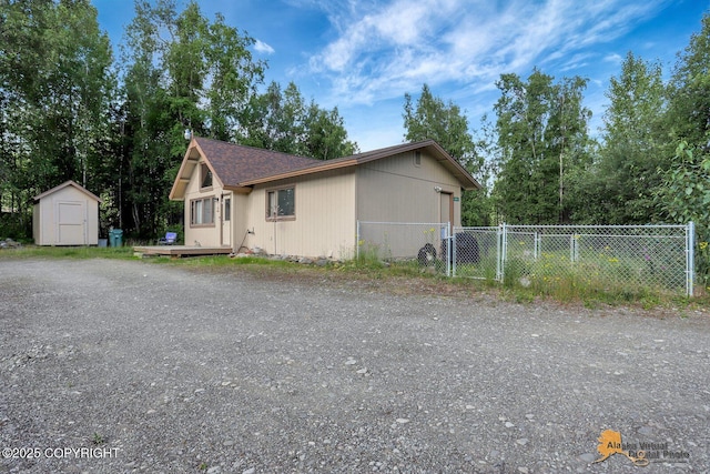 14854 W Fox, Big Lake, AK 99623 - view of property exterior with a storage shed, a wooden deck, and a shingled roof