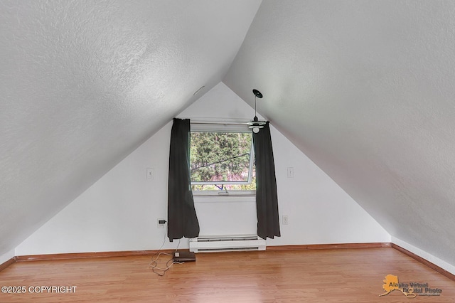 14854 W Fox, Big Lake, AK 99623 - additional living space featuring a baseboard radiator, a textured ceiling, wood finished floors, and lofted ceiling