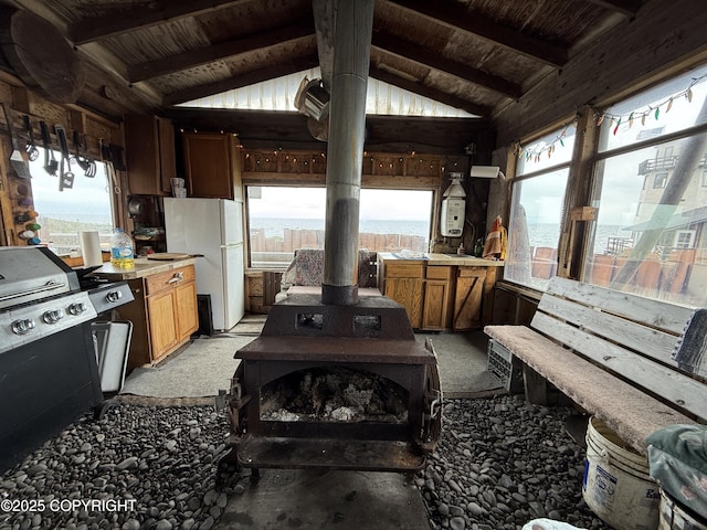 25646 Hawks Beach Rem SW, Anchor Point, AK 99556 - kitchen with freestanding refrigerator, a wood stove, light countertops, wood ceiling, and light colored carpet