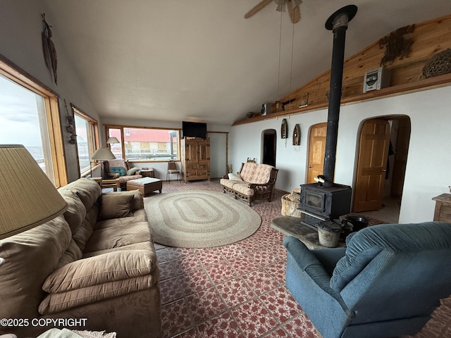 25646 Hawks Beach Rem SW, Anchor Point, AK 99556 - living room with a wood stove, lofted ceiling, arched walkways, a ceiling fan, and carpet flooring