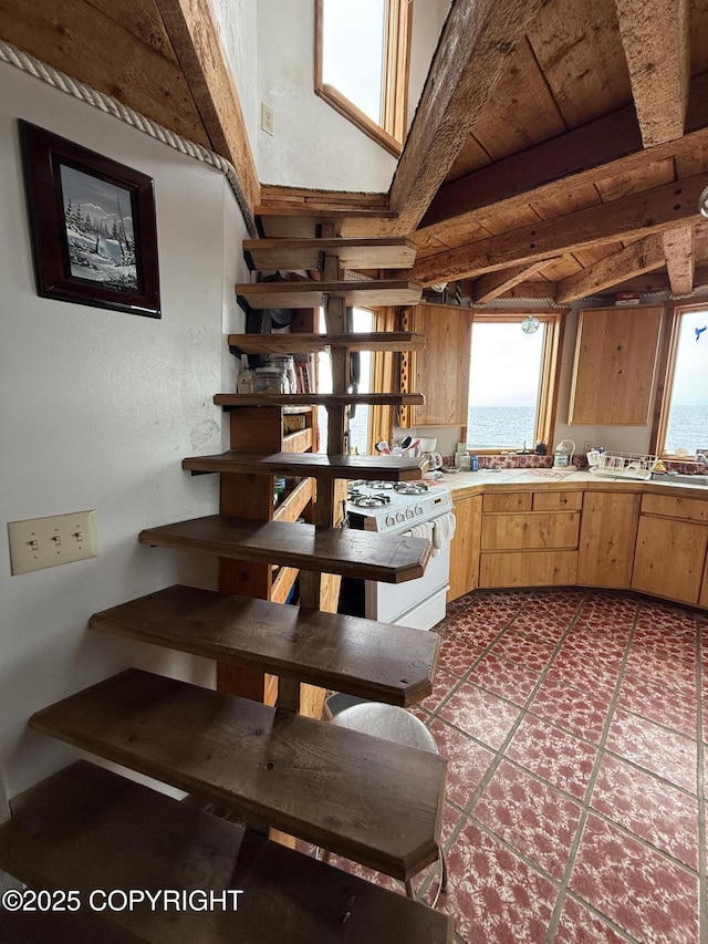 25646 Hawks Beach Rem SW, Anchor Point, AK 99556 - kitchen featuring white range with gas stovetop, beamed ceiling, and light countertops