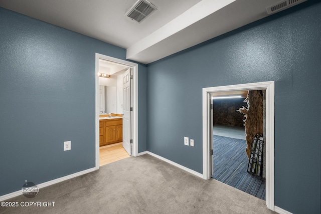5622 E 4th Ave Unit 12, Anchorage, AK 99504 - unfurnished bedroom featuring light carpet and ensuite bath