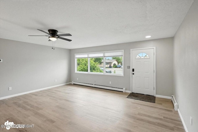 4335 E 6th Ave, Anchorage, AK 99508 - entryway featuring baseboard heating, a ceiling fan, light wood-type flooring, and a textured ceiling