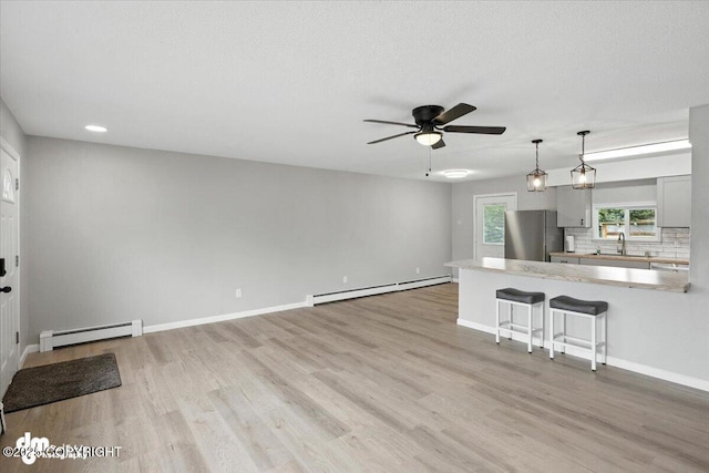 4335 E 6th Ave, Anchorage, AK 99508 - unfurnished living room with a baseboard heating unit, a ceiling fan, light wood-type flooring, and recessed lighting