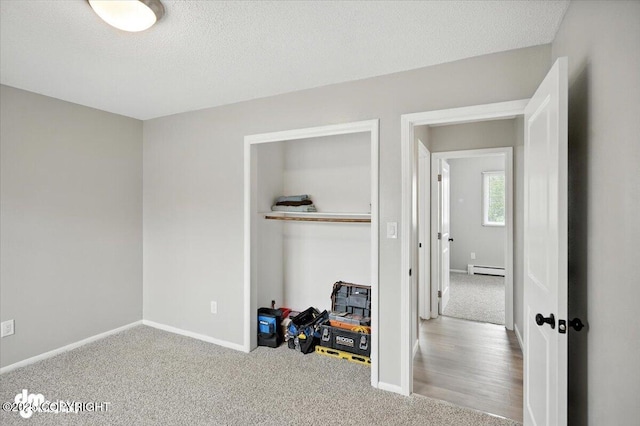 4335 E 6th Ave, Anchorage, AK 99508 - carpeted bedroom featuring baseboard heating, a textured ceiling, and a closet