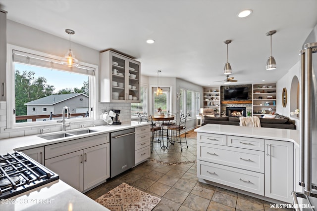 15250 Evergreen Ridge St, Anchorage, AK 99516 - kitchen with dishwasher, open floor plan, a ceiling fan, stovetop, and a large fireplace